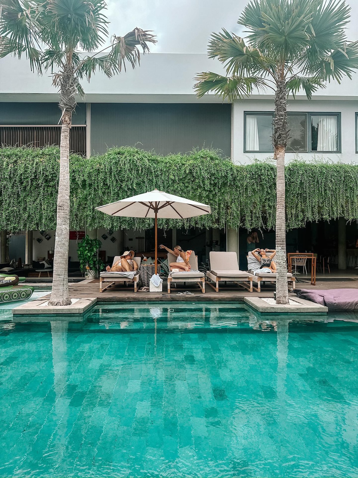 Guests relaxing by the pool in the villa's tropical Bingin setting