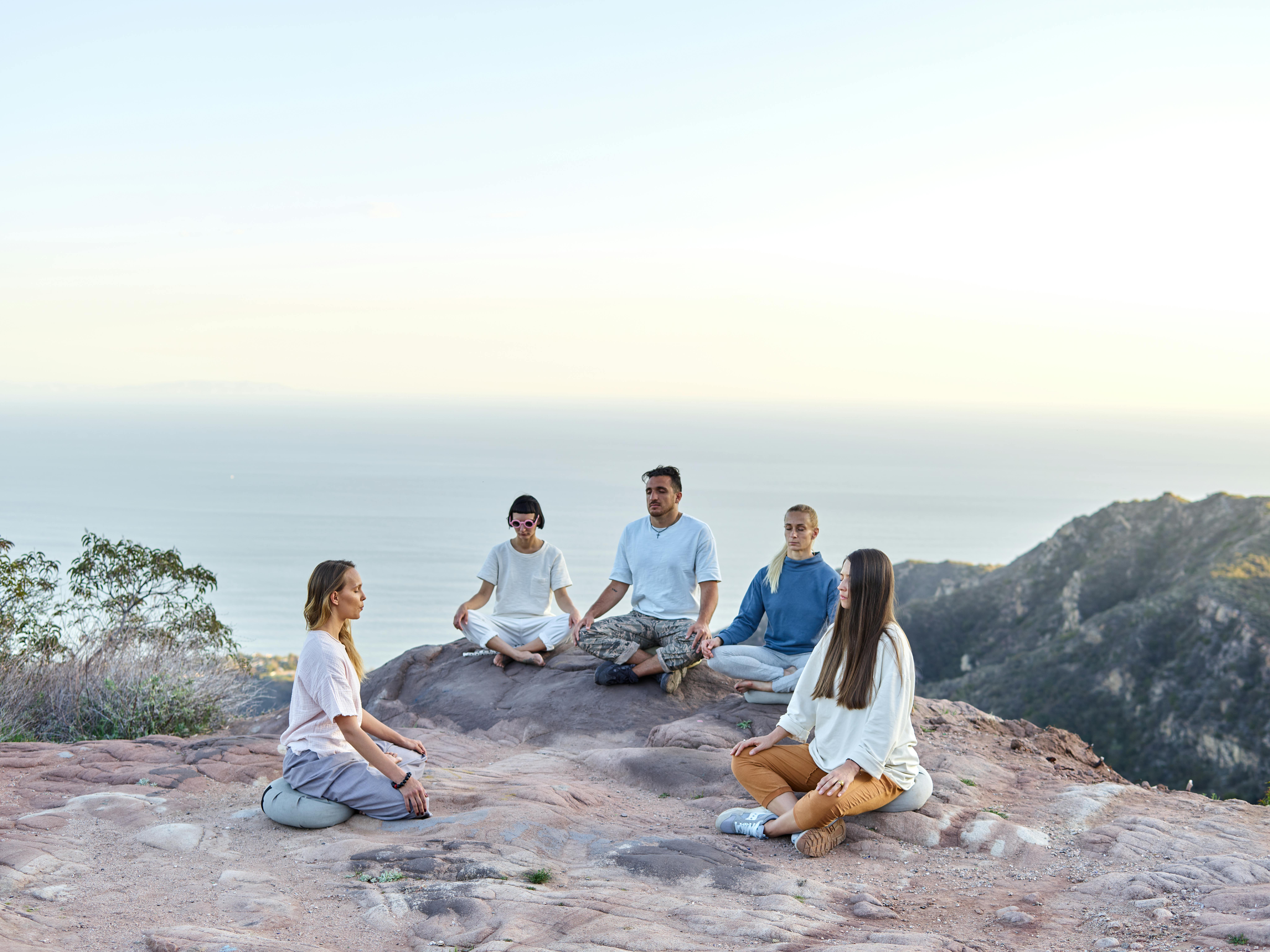 Group meditation and mindfulness session in a calm outdoor setting